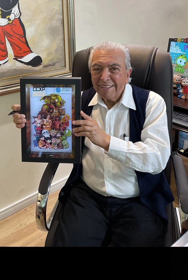 Mauricio de Sousa segurando a shadowbox dos 50 anos da Turma da Mônica