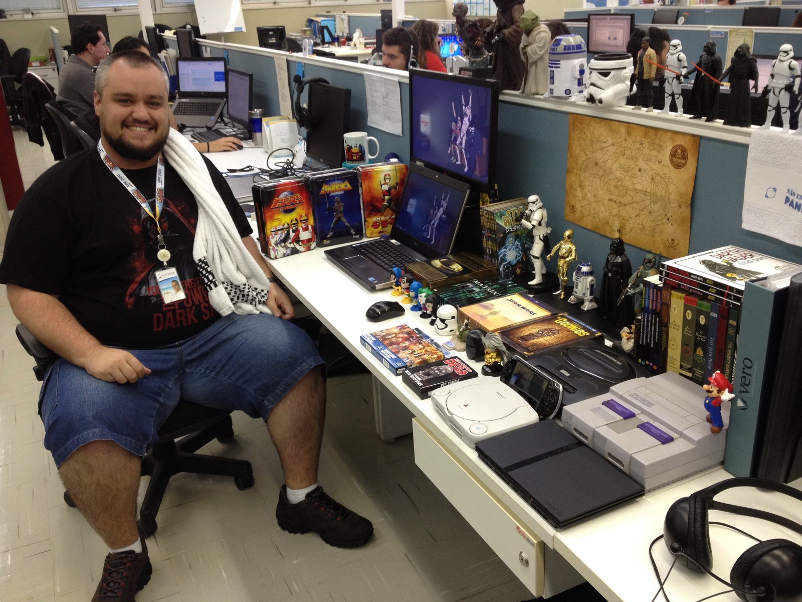 Colaborador da Matera na sua mesa com coleção de action figures, games e quadrinhos